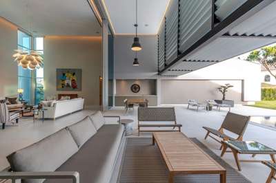 Seamless indoor-outdoor living space with modern lounge seating, dining area, and sleek tiled floors in Quinta do Lago.