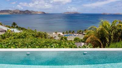 Sweeping ocean and bay views from the edge of the heated infinity pool at the exclusive Villa Adharra in Pointe Milou.