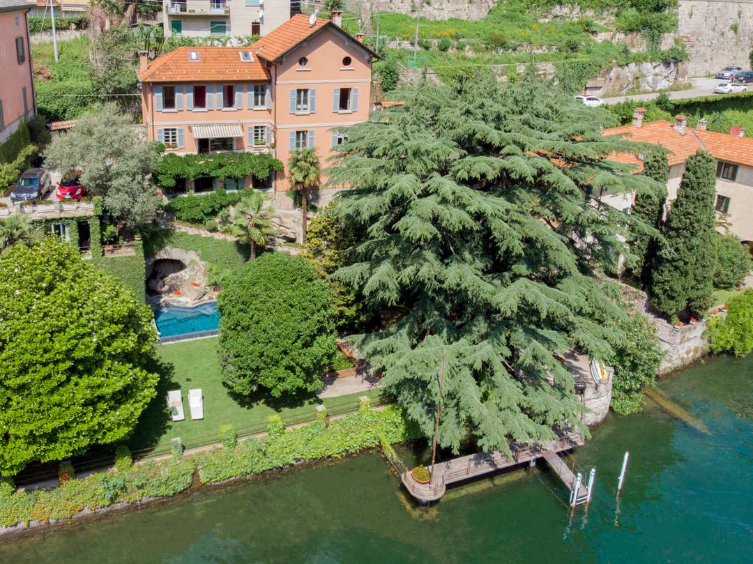 Aerial view of Villa Adria on Lake Como, showcasing the private pool, lush manicured gardens, and direct waterfront access.