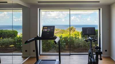 Luxury villa fitness room with a treadmill, stationary bike, and inspiring ocean views in St-Barths.