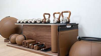 Luxury fitness equipment at Villa Amitié, featuring elegant wooden kettlebells, dumbbells, and leather medicine balls.