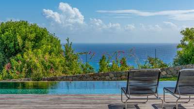 Relax on sleek sun loungers by the heated infinity pool at Villa Angel, overlooking breathtaking Caribbean Sea views.