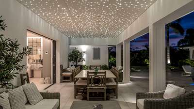 Covered alfresco dining terrace at Villa Antares featuring a sparkling starlit ceiling, elegant seating, and ocean breezes.