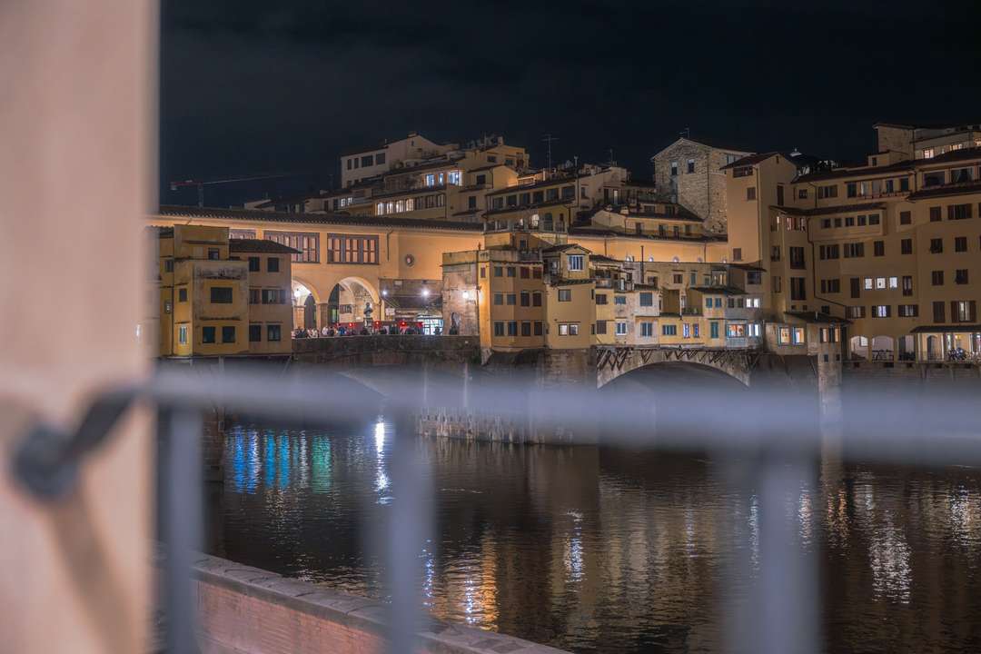 Stunning night view of Florence's iconic Ponte Vecchio and Arno River from the elegant Arnova Apartment.