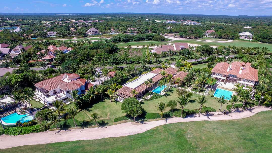 Aerial view of Arrecife Luxury Estate in Punta Cana, featuring elegant villas with private pools and lush golf course views.