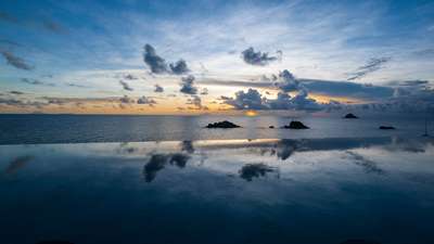 Dramatic Caribbean sunset reflecting on the magnificent 17-meter heated infinity pool with uninterrupted ocean views.