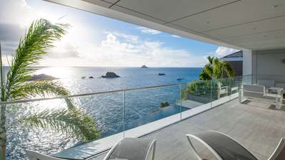 Stunning private terrace in Bedroom 2 with glass railings, modern lounge seating, and spectacular Caribbean ocean views.