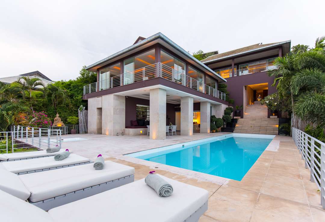 Luxury Koh Samui villa exterior featuring a 15m lap pool, limestone terrace, and sleek modern architecture at Baan Fan Noi.