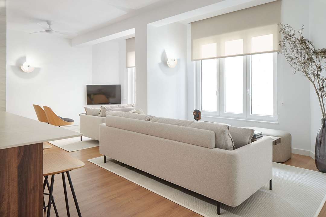 Bright luxury living area in San Sebastián with contemporary furnishings, earthy tones, and warm wood floors.