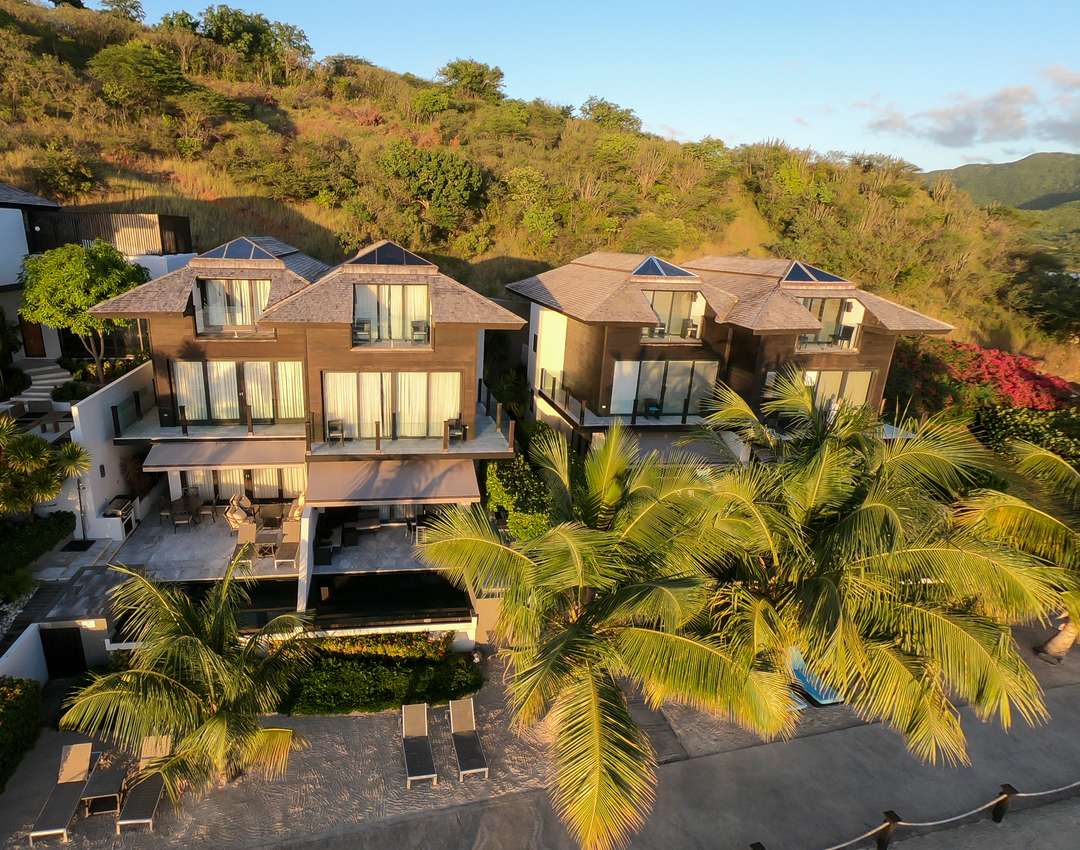 Aerial view of Beach House 5 at Tamarind Hills, featuring elegant multi-story architecture, private pools, and beach access.