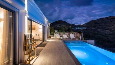 Stunning illuminated private pool and expansive terrace at night, showcasing elegant indoor-outdoor Caribbean living.