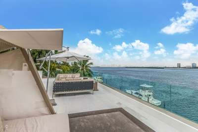 Expansive rooftop terrace with modern lounge seating offering panoramic views of Biscayne Bay and the Miami city skyline.