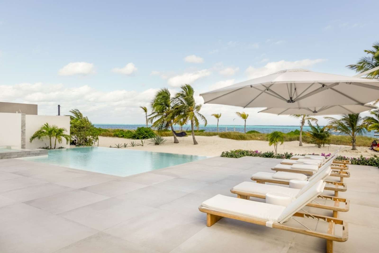Bliss Villa Two, Grace Bay – Infinity pool and sun deck with loungers at Bliss Villa Two, offering stunning beachfront ocean views in Grace Bay.