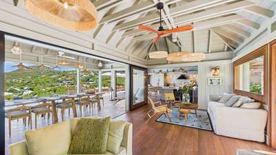 Spacious air-conditioned living area with exposed beams, natural wood accents, and breathtaking views of St-Jean Bay.