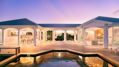 Breathtaking sunset views reflected in the private pool of Villa Byzance, highlighting its elegant open-air arched design.
