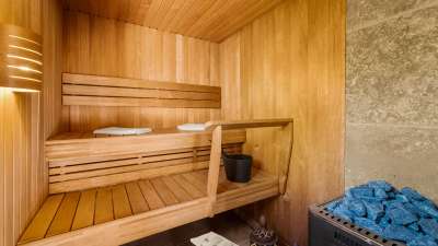 Exclusive private sauna featuring tiered wooden benches and hot stones, perfect for unwinding at this Marbella villa.