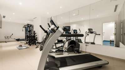 State-of-the-art private gym in Golden Carolina villa with treadmill, elliptical, and free weights for luxury living.