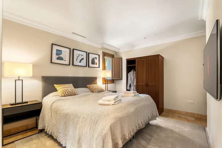 Contemporary bedroom with a double bed, elegant wooden wardrobe, and modern decor at the luxury Golden Carolina villa.