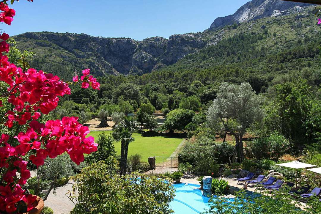 Breathtaking mountain views over the hillside private pool and lush terraced gardens at The Olive Press Estate in Pollensa.