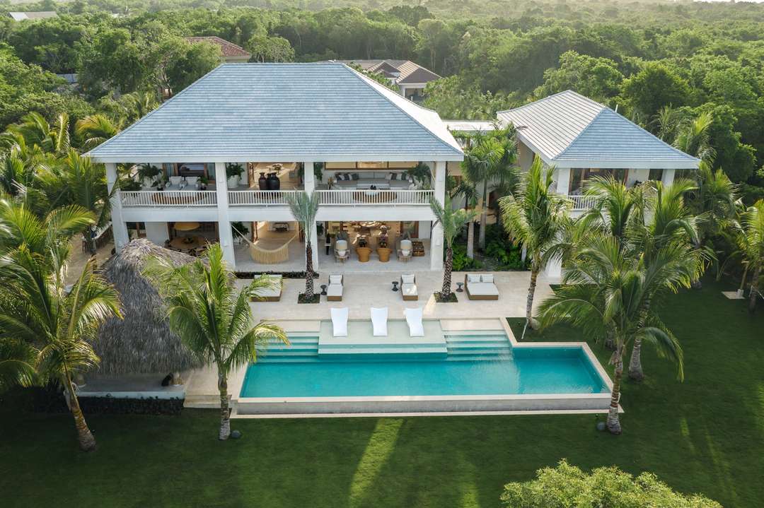 Aerial view of Casa Calma's private pool, elegant terrace, traditional palapa, and lush tropical gardens in Punta Cana.