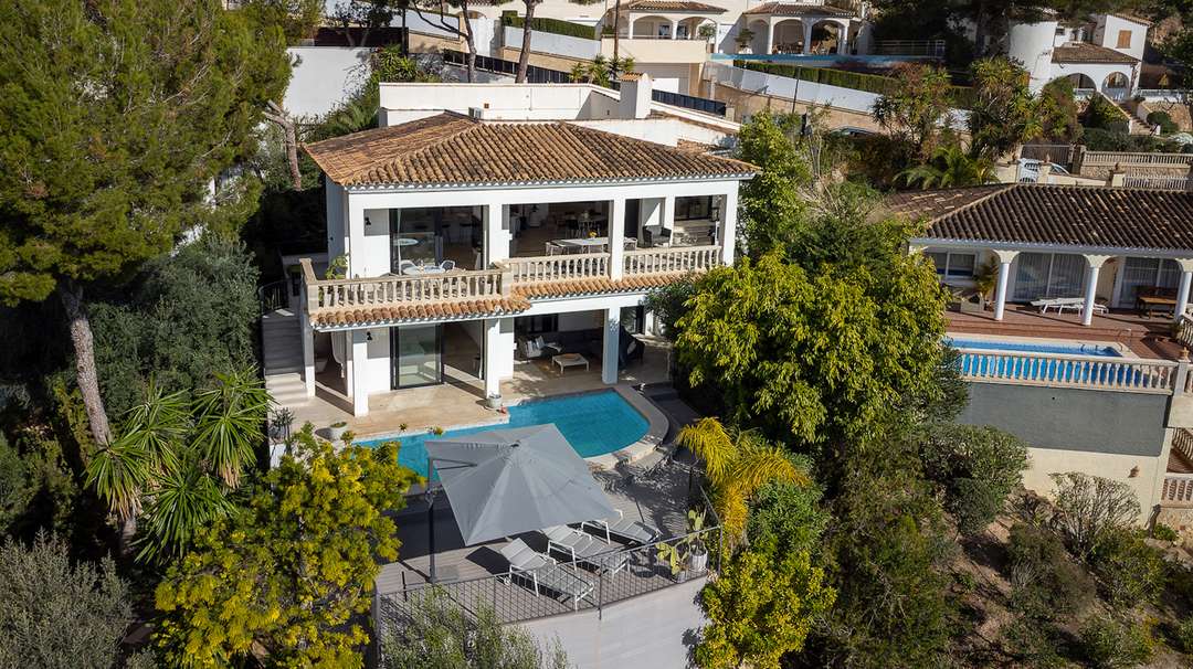 Aerial view of The Portals Vantage, a luxury villa in Costa d'en Blanes featuring a private pool, terraces, and lush gardens.
