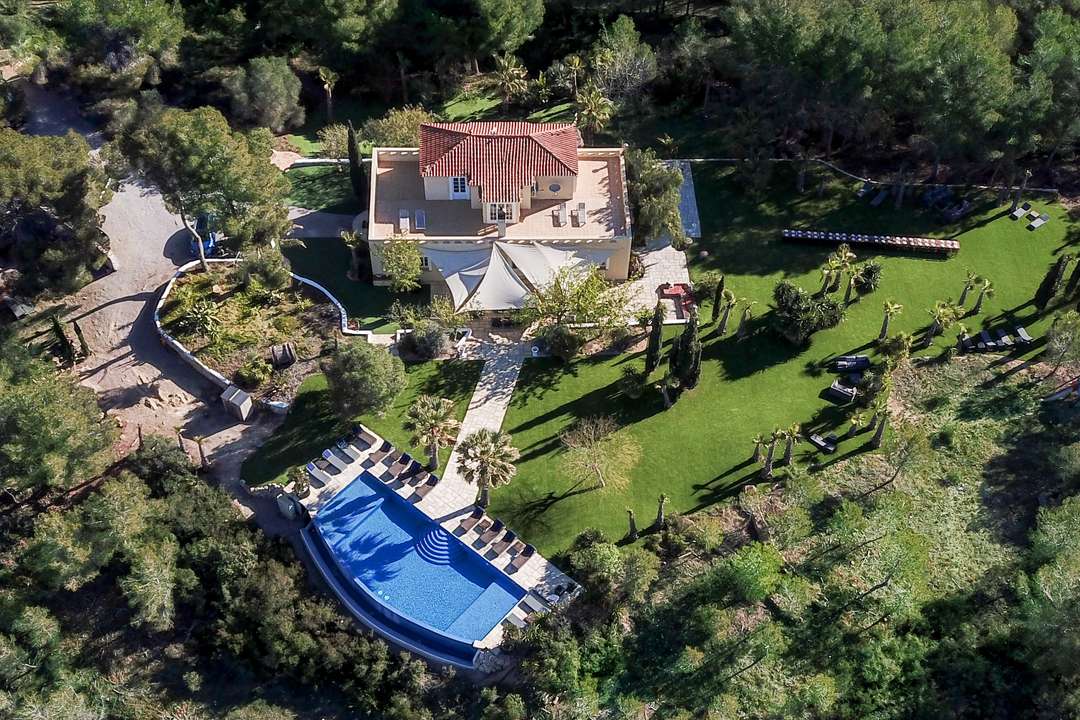 Aerial view of Casa Nova Estate, a luxurious Catalan manor featuring a stunning infinity pool and lush gardens in Sitges.
