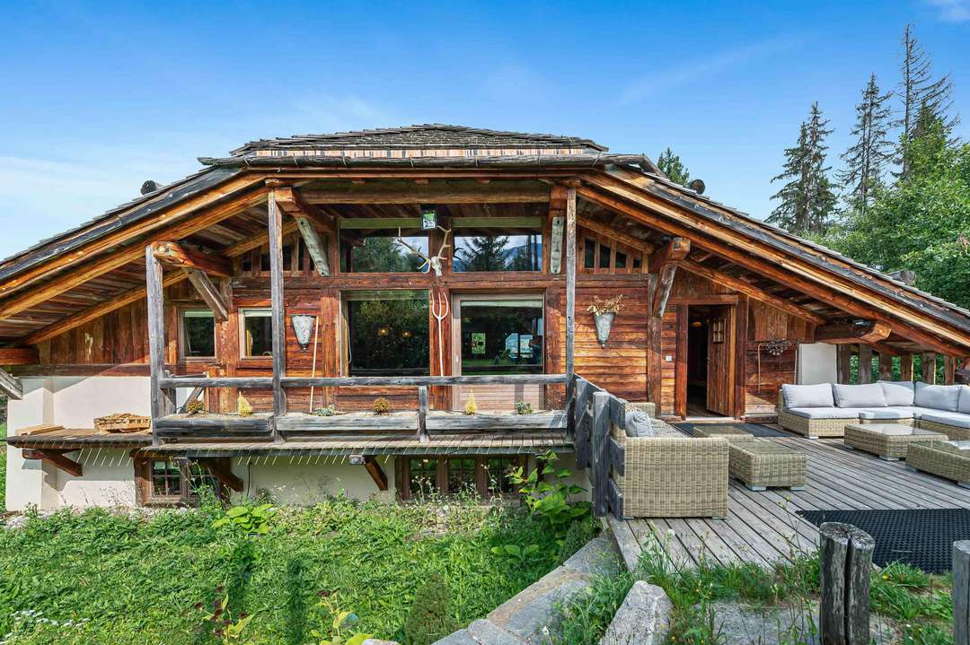 Exterior of luxury Chalet Arielle in Megève featuring traditional alpine wood design, spacious terrace, and mountain views.