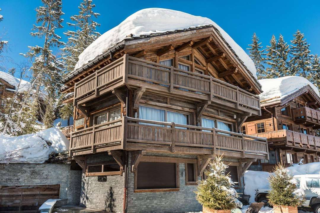 Luxury Chalet Eden exterior in Courchevel 1850, featuring traditional alpine wood architecture and a snowy mountain setting.
