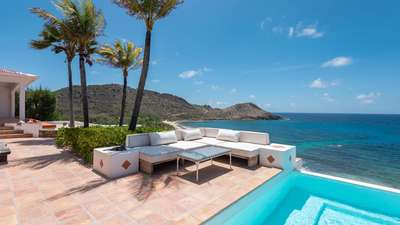 Comfortable outdoor seating by the private pool overlooking the sparkling Caribbean Sea at Villa Chant De L'océan in Toiny.