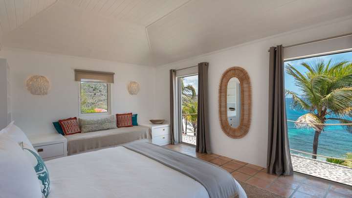Bedroom 3 boasts a king bed, daybed, terracotta floors, and panoramic ocean views through sliding doors in St-Barths.