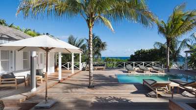 Caribbean-style villa terrace at Citron Vert Estate featuring a private pool, wooden deck, and shaded outdoor lounge area.