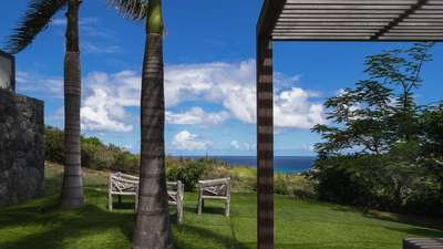 Breathtaking ocean views framed by a wooden pergola and lush tropical gardens at the luxurious Villa Coco Rock.