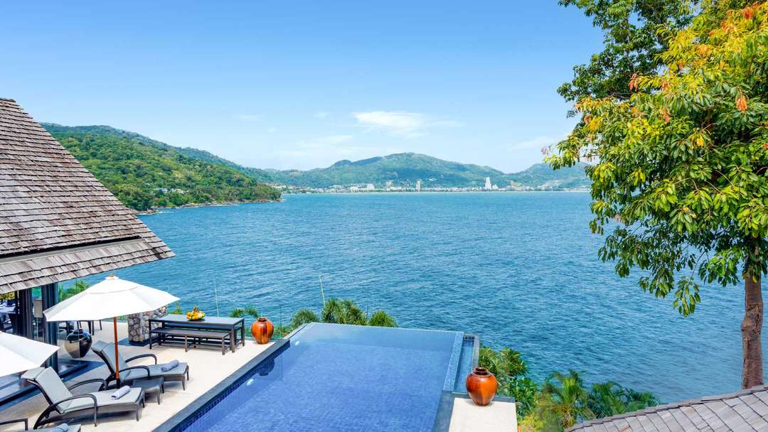 Luxury Phuket villa infinity pool with sun loungers, offering panoramic Andaman Sea views and elegant outdoor living.