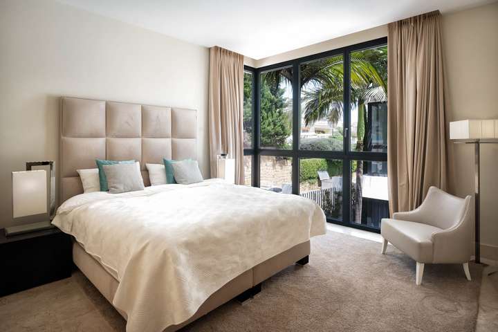 Luxurious bedroom in El Chambao Penthouse offering a king-size bed, contemporary furnishings, and bright tropical views.