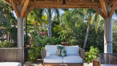 Serene wooden gazebo with plush white seating surrounded by lush tropical gardens at luxury Villa Endeavour in St. Barths.