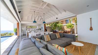 Expansive open-plan living area with a vaulted ceiling, plush seating, and elegant dining space overlooking the private pool.