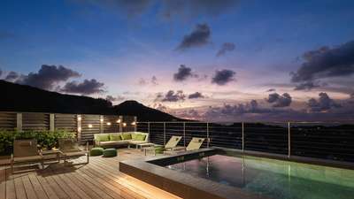 Stunning sunset ocean views from the expansive wooden terrace, heated pool, and chic outdoor lounge at Villa Feyrouz.