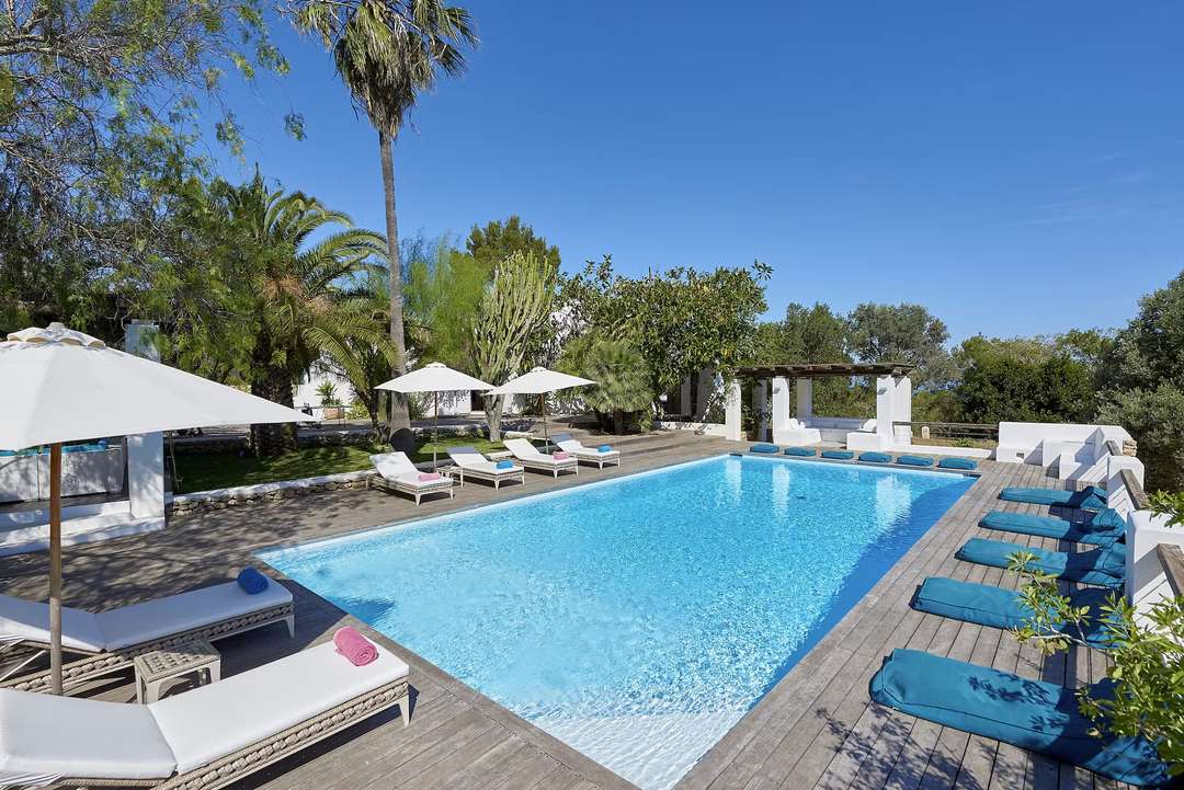 Turquoise 11m x 5m private pool at Finca Lavanda, surrounded by a wooden deck, sun loungers, and Mediterranean gardens.