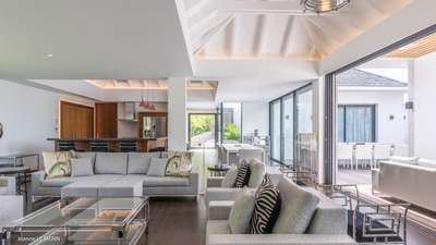Elegant open-plan living and dining area in St. Barths featuring contemporary design, soft linen tones, and terrace access.