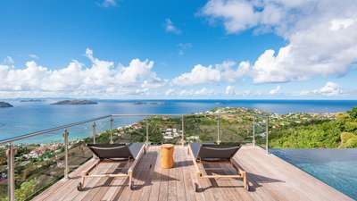 Twin sun loungers and a wooden side table on the terrace at Golden View, providing a serene spot for panoramic ocean views.