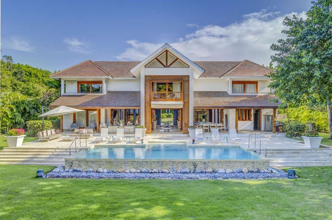 Elegant Hacienda 82 exterior in Punta Cana, featuring a private pool, stone terrace, and lush manicured garden views.