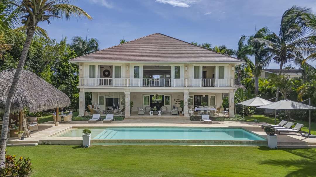 Hacienda Dream in Punta Cana features a private pool, spacious stone terrace, and a thatched gazebo amidst tropical gardens.