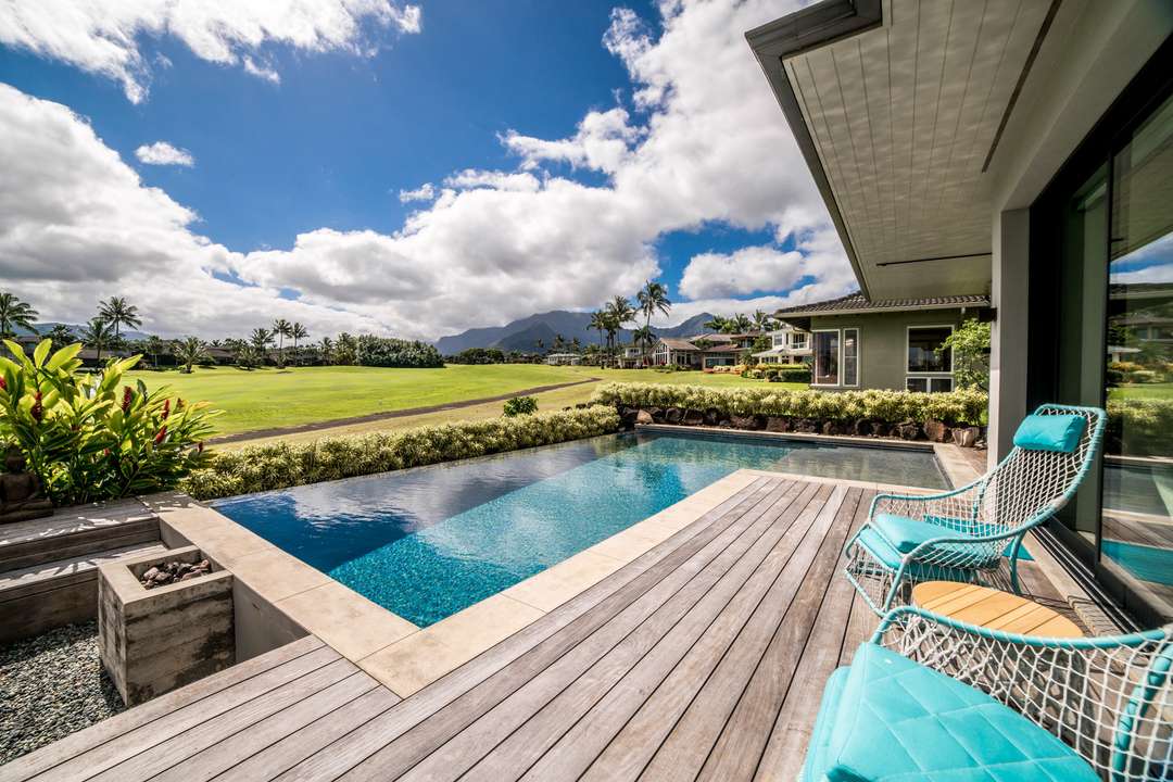 Private pool and wooden deck at Hale Queen Emma, offering stunning golf course and mountain views in Kauai.
