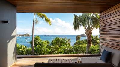 Private teak terrace with comfortable lounge seating, offering spectacular panoramic views of the azure Caribbean Sea.