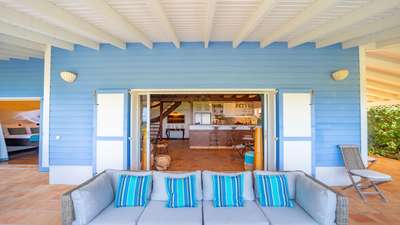 Elegant outdoor lounge area with plush seating, offering a seamless transition into the villa's spacious indoor living room.