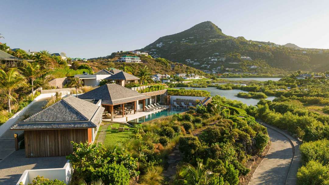 Aerial view of Villa Lazuli in Grand-Cul-de-Sac, featuring a private pool, lush tropical gardens, and sweeping ocean vistas.