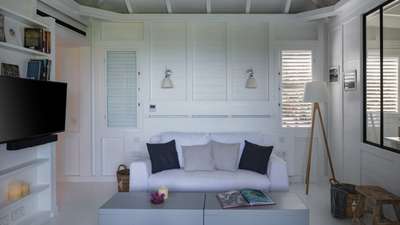 Bright, uncluttered living area featuring a plush white sofa, elegant decor, and modern amenities in this luxury villa.