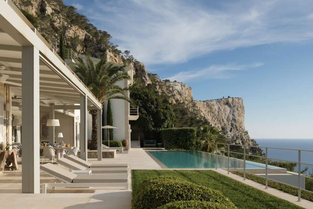 Luxury villa Luz del Sol terrace with sun loungers, heated infinity pool, and breathtaking sea and cliff views in Mallorca.