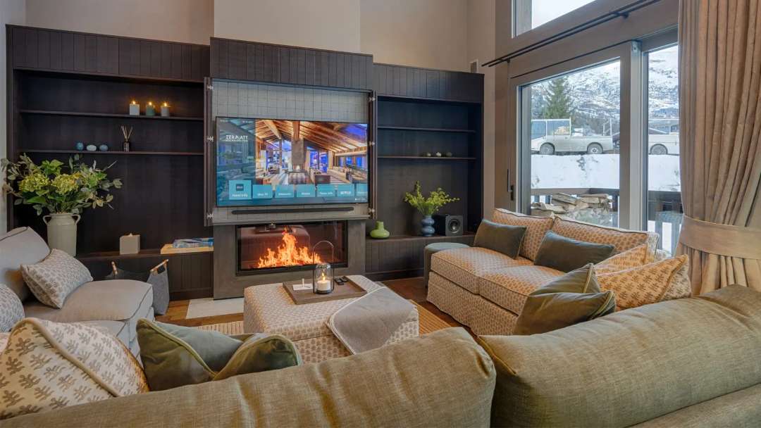 Elegant living room at Lyskamm Lodge with open fireplace, smart TV, and smoked oak herringbone flooring.