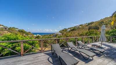 Comfortable sunbeds on the expansive teak terrace of Villa Mademoiselle, offering tranquil ocean and mountain views in Toiny.